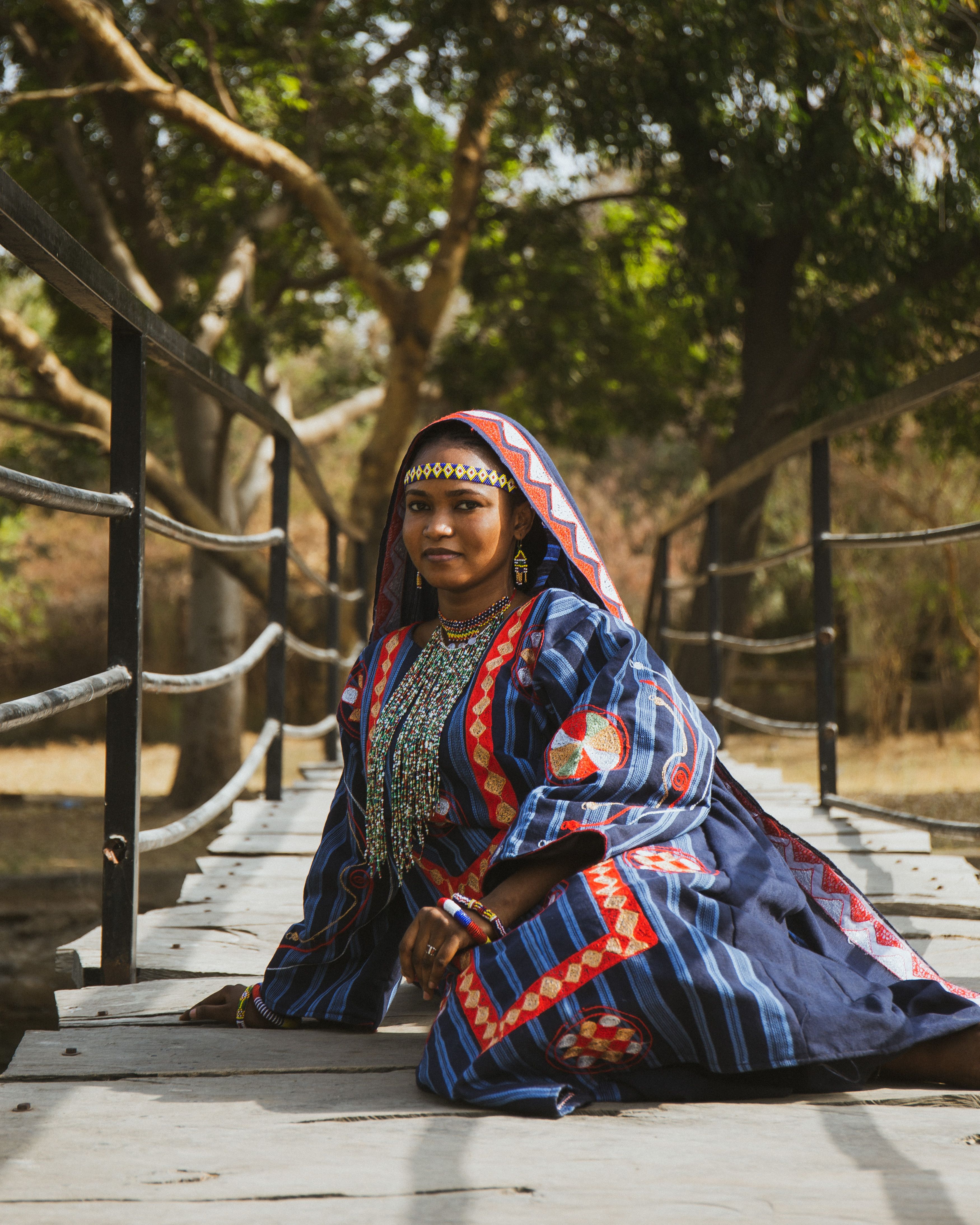 Fulani Woman in Traditional Attire on Bridge · Free Stock Photo