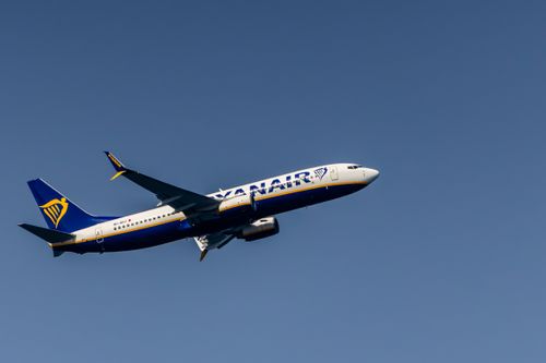 Free Ryanair airplane flying high against a clear blue sky in Cinisi, Sicily, Italy. Stock Photo
