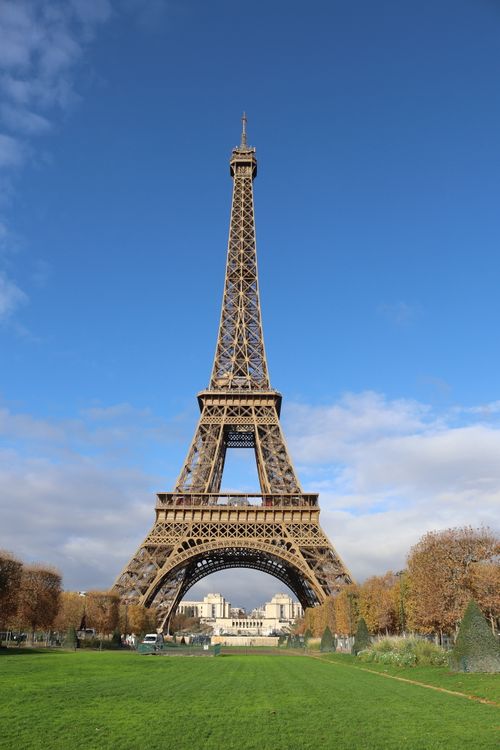 Free A stunning view of the Eiffel Tower in Paris, framed by a clear blue sky. Stock Photo