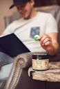 Man in White Crew Neck T-shirt Holding Green and White Gummy Ring