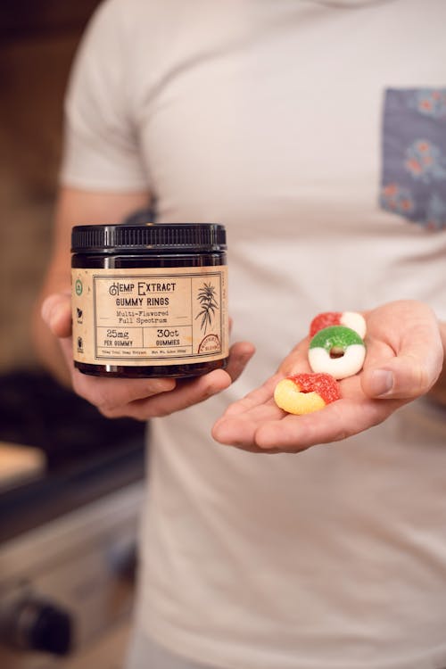 Person Holding A Jar And Gummy Candies