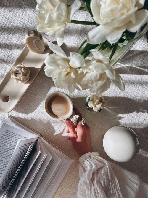 Free Serene flat lay with coffee, white flowers, and an open book, perfect for a cozy lifestyle scene. Stock Photo