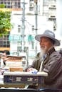 Elderly Asian Man Sitting by Outdoor Market Stall