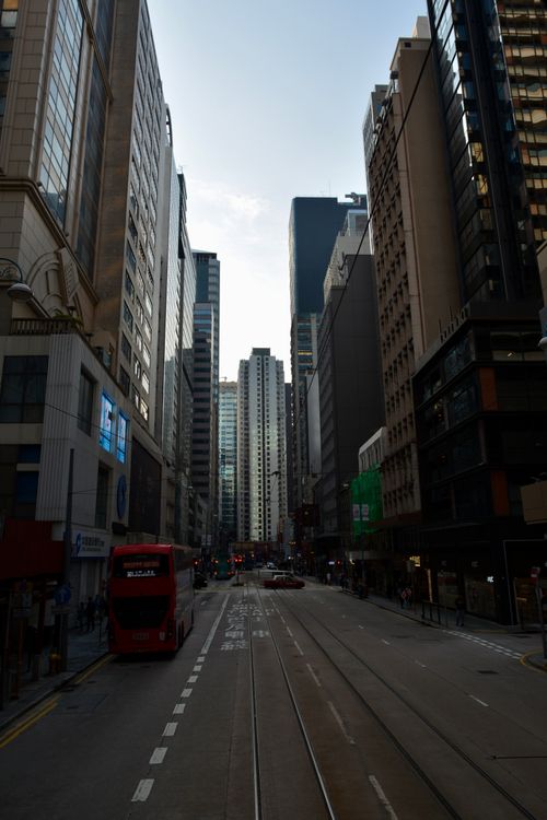 Free A dynamic view of a busy street in Hong Kong surrounded by tall skyscrapers at dusk. Stock Photo