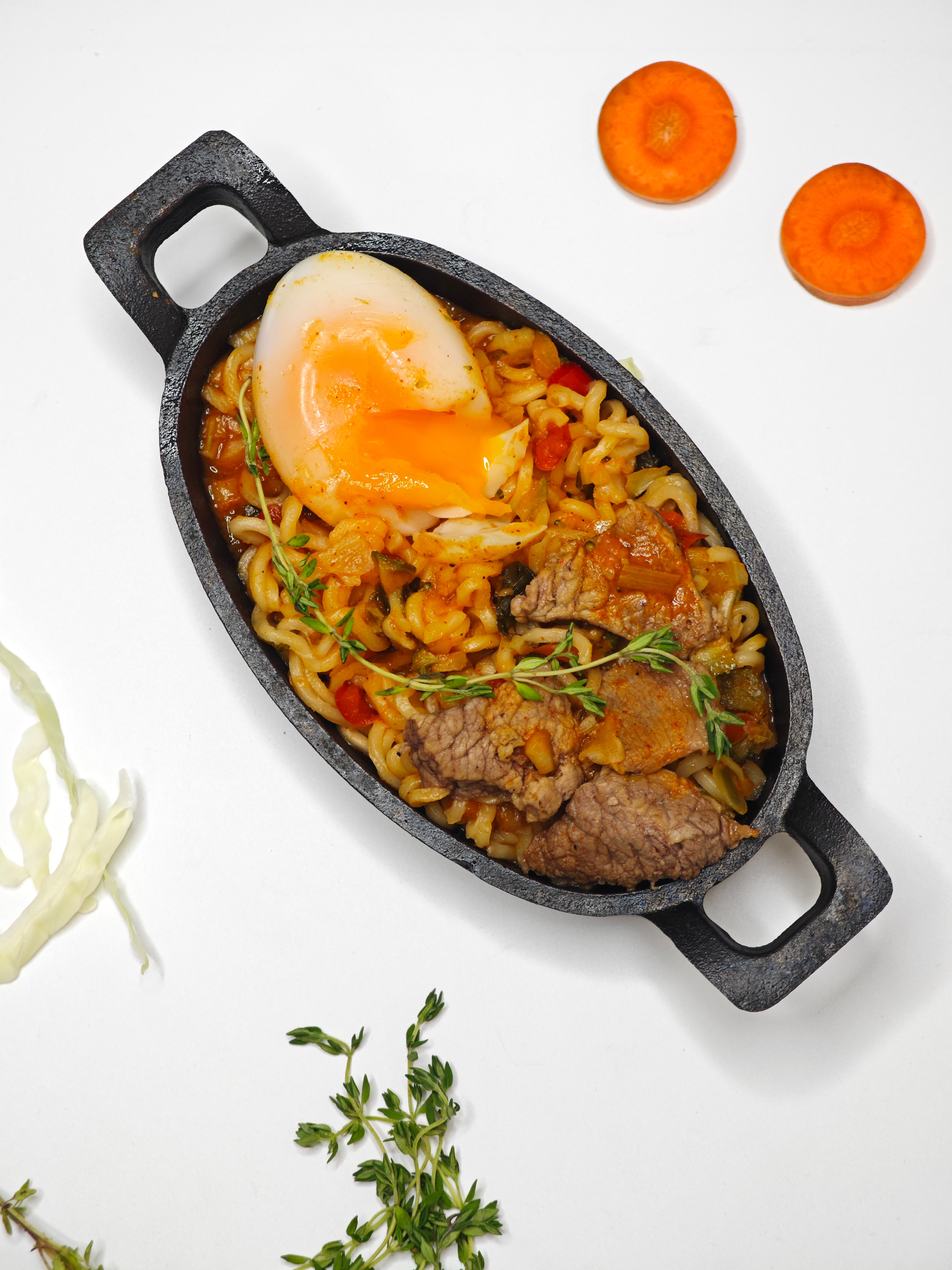 Savor this tasty cast iron skillet dish with beef, noodles, and a perfectly poached egg.