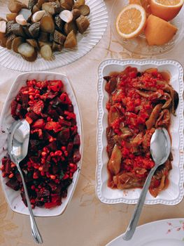 Aerial view of assorted vegetarian dishes with pickles and oranges.