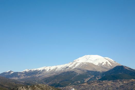 Breathtaking snow-capped mountain landscape under a clear blue sky in Isparta, Türkiye.