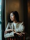 一位穿着西装的自信女性凝视着窗外，散发着专业与优雅