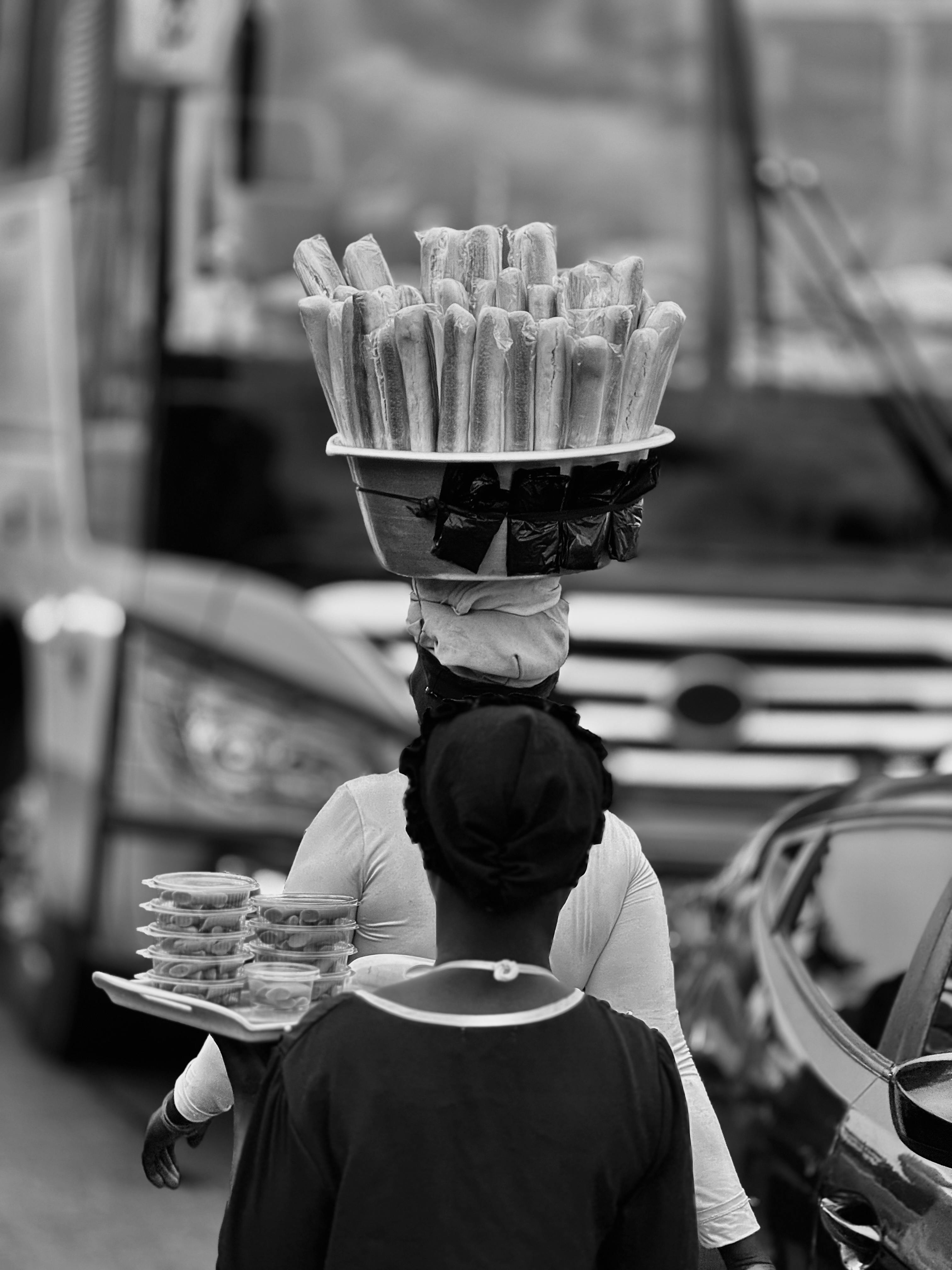 Ücretsiz Gana'nın Accra şehrinde, başının üzerinde atıştırmalıklar taşıyan bir sokak satıcısı, yerel yemek kültürünü sergiliyor. Stok Fotoğraflar