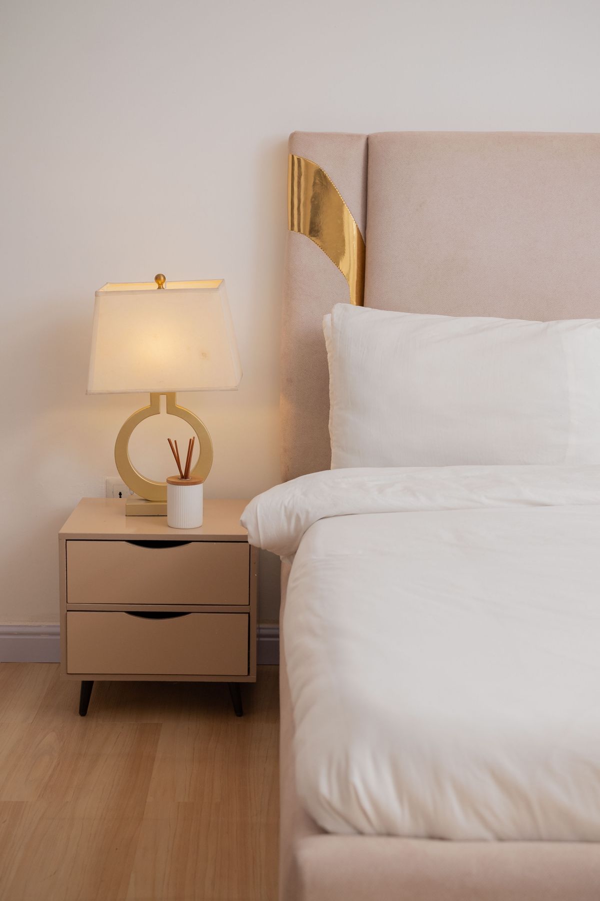 Elegant modern bedroom with bedside lamp, nightstand and refined neutral styling