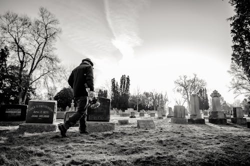 Photo Monochrome D'un Homme Marchant Dans Le Cimetière