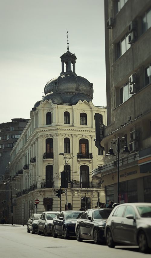 Free Elegant historic building with a unique dome in Bucharest amidst city street traffic. Stock Photo