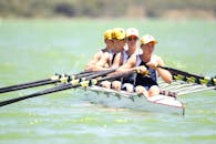 在阳光明媚的日子里，一支由年轻赛艇运动员组成的队伍整齐划一地行动，象征着团队合作与拼搏精神