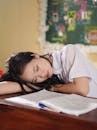 Young Student Sleeping on Classroom Desk