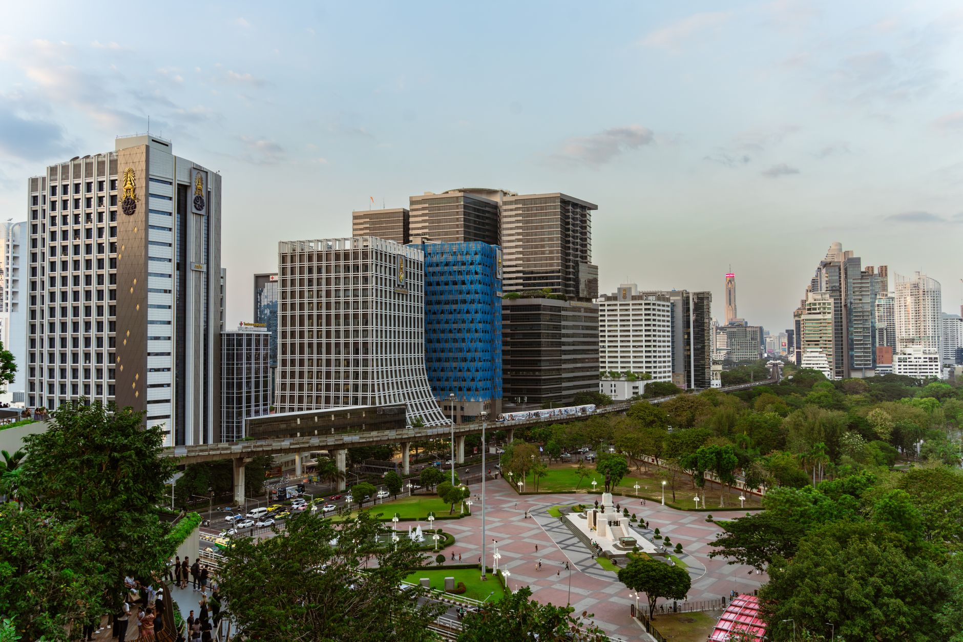 Joggers around the lake at Lumphini Park with Bangkok skyline behind