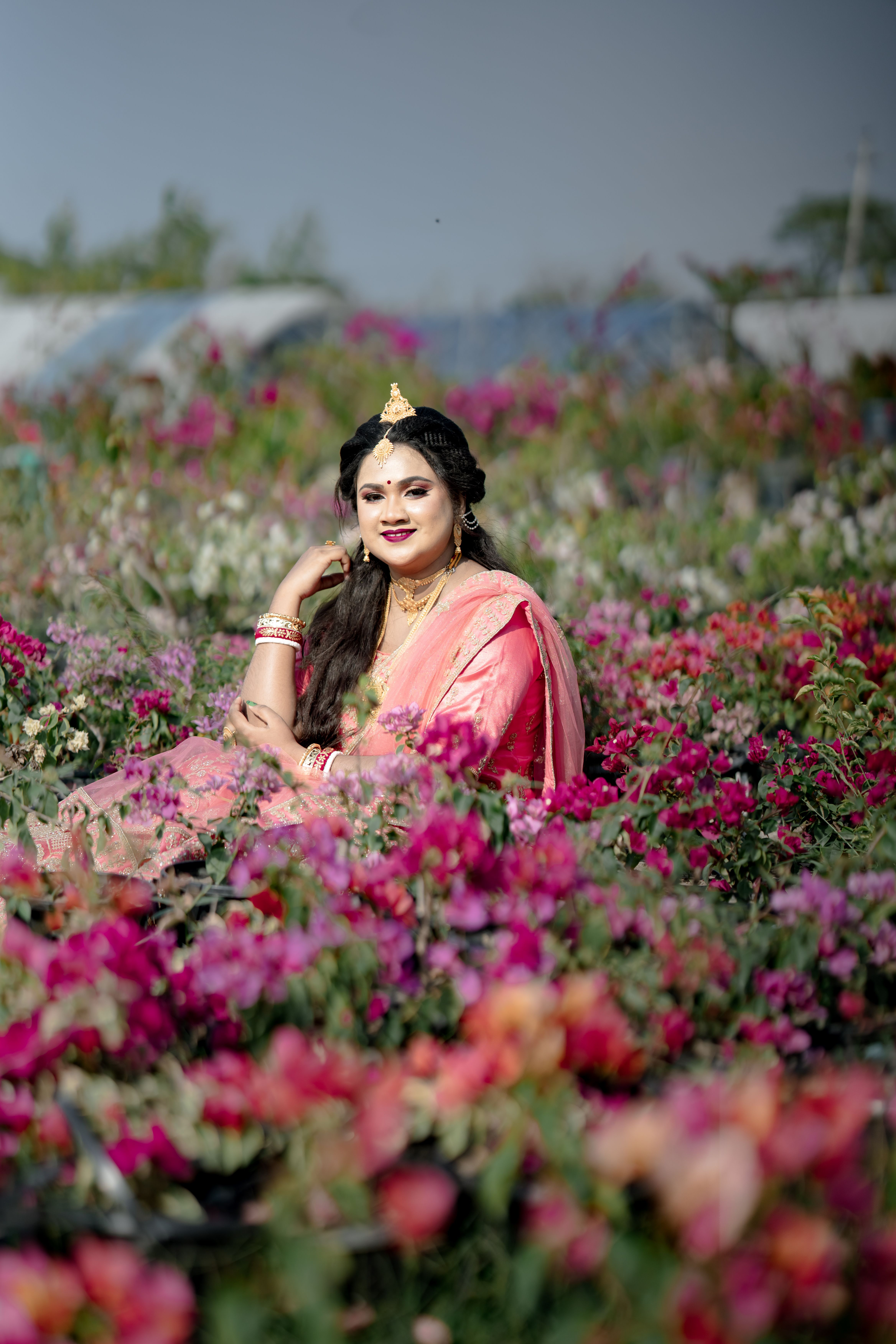 Portrait of a woman in traditional attire surrounded by colorful flowers.