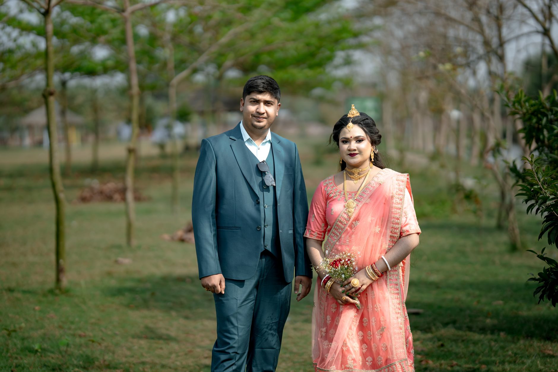 Beautiful outdoor portrait of a couple in traditional wedding attire, showcasing elegance and joy.