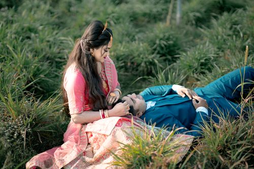 Free A loving couple in traditional attire sharing a moment on a grassy field, symbolizing romance and tradition. Stock Photo