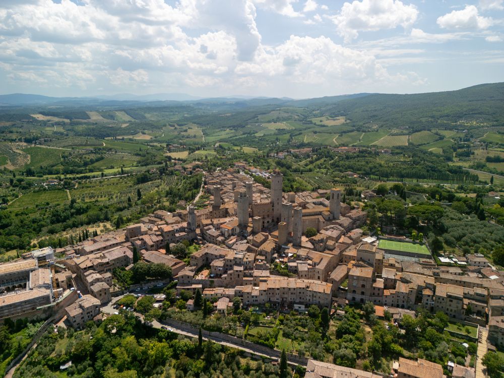 Vedere aeriană a orașului medieval San Gimignano înconjurat de dealuri toscane