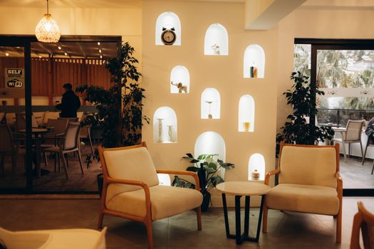 A stylish indoor cafe with modern decor, featuring comfortable seating and illuminated niches.