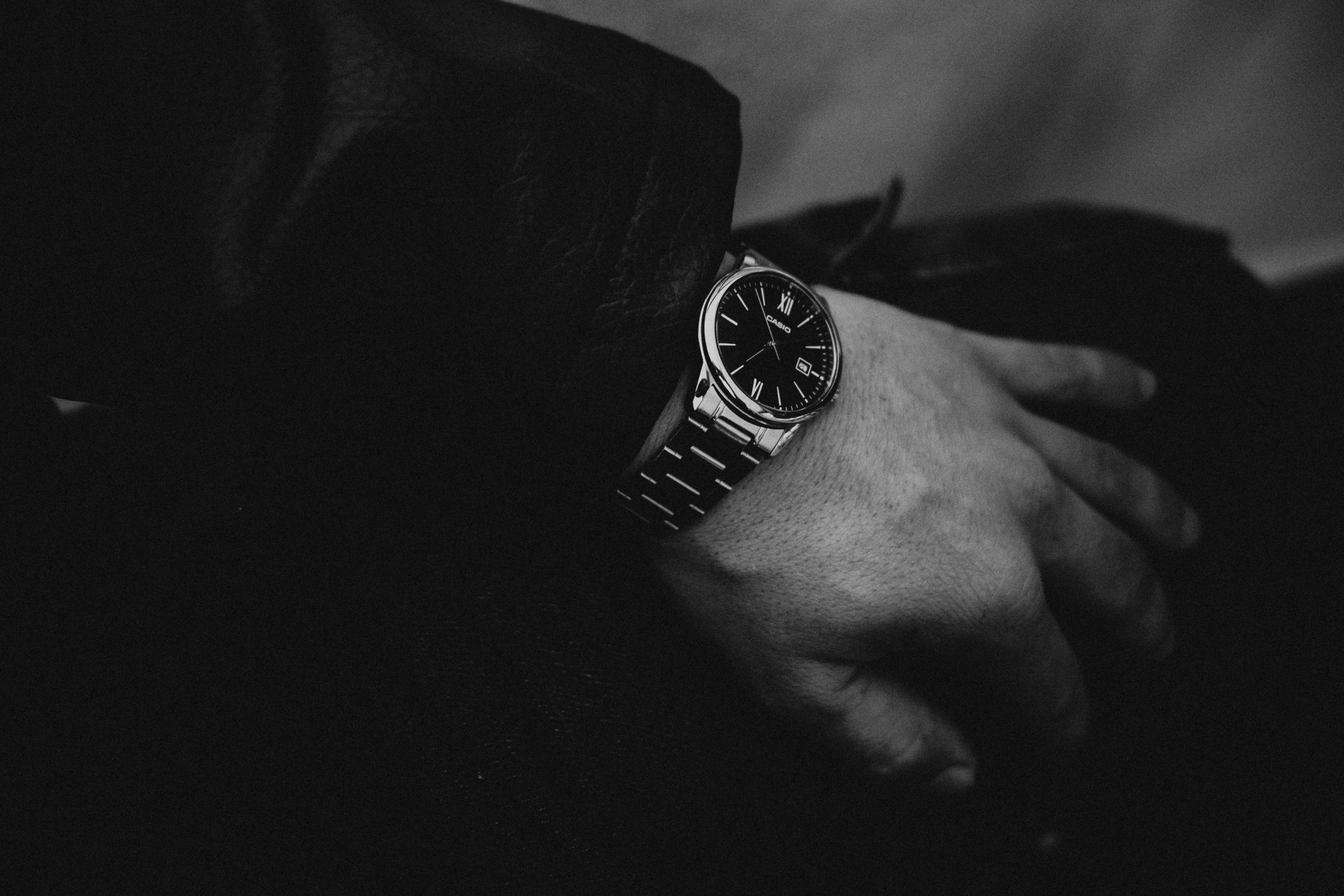 Gratis Primo piano monocromatico di un elegante orologio da polso con numeri romani sul polso di un adulto. Foto a disposizione