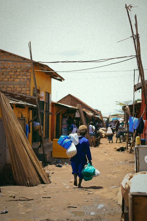 Free A bustling market street scene with people carrying goods in a developing region. Stock Photo
