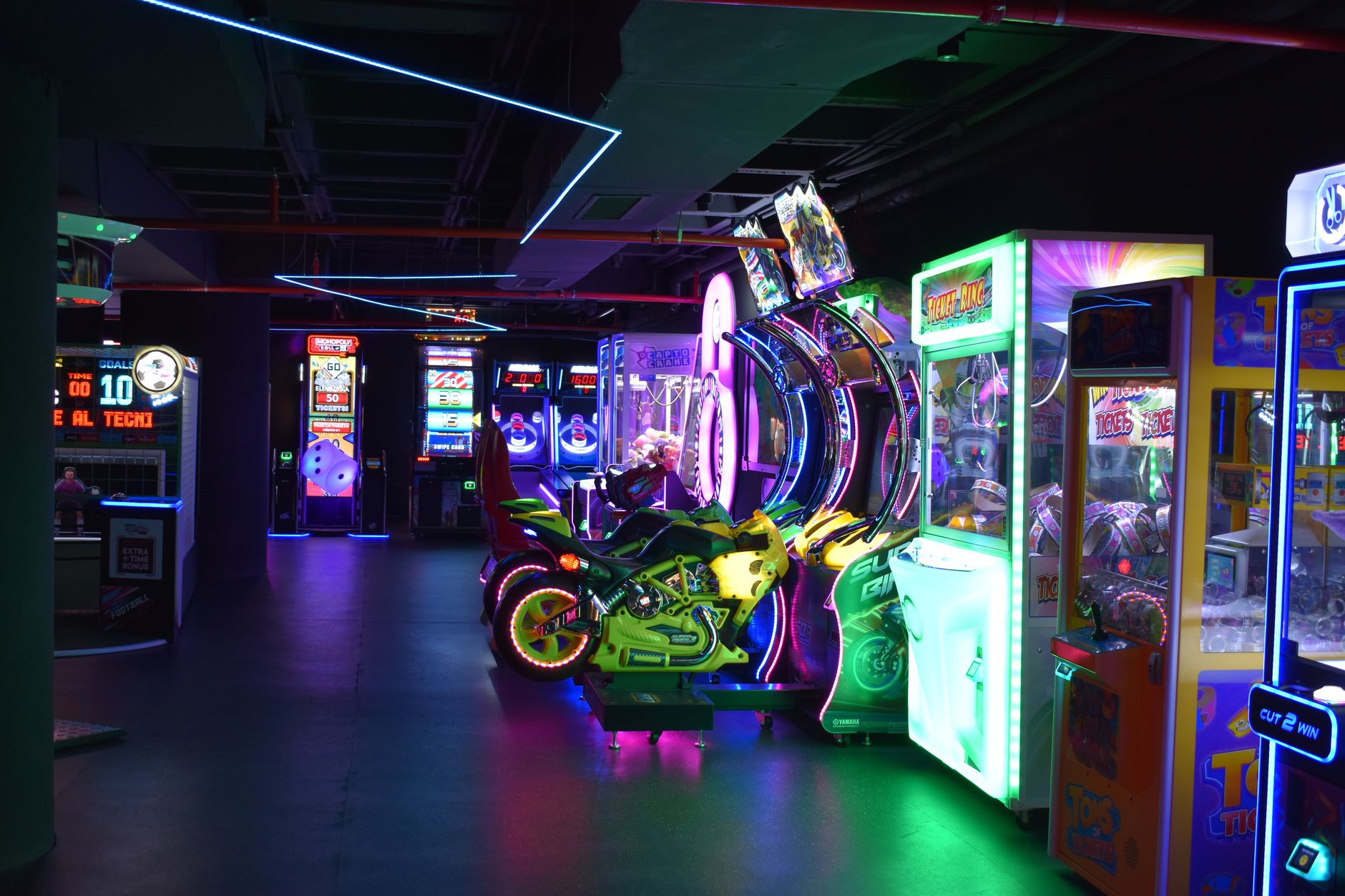 Explore a lively arcade filled with colorful neon lights and various gaming machines.