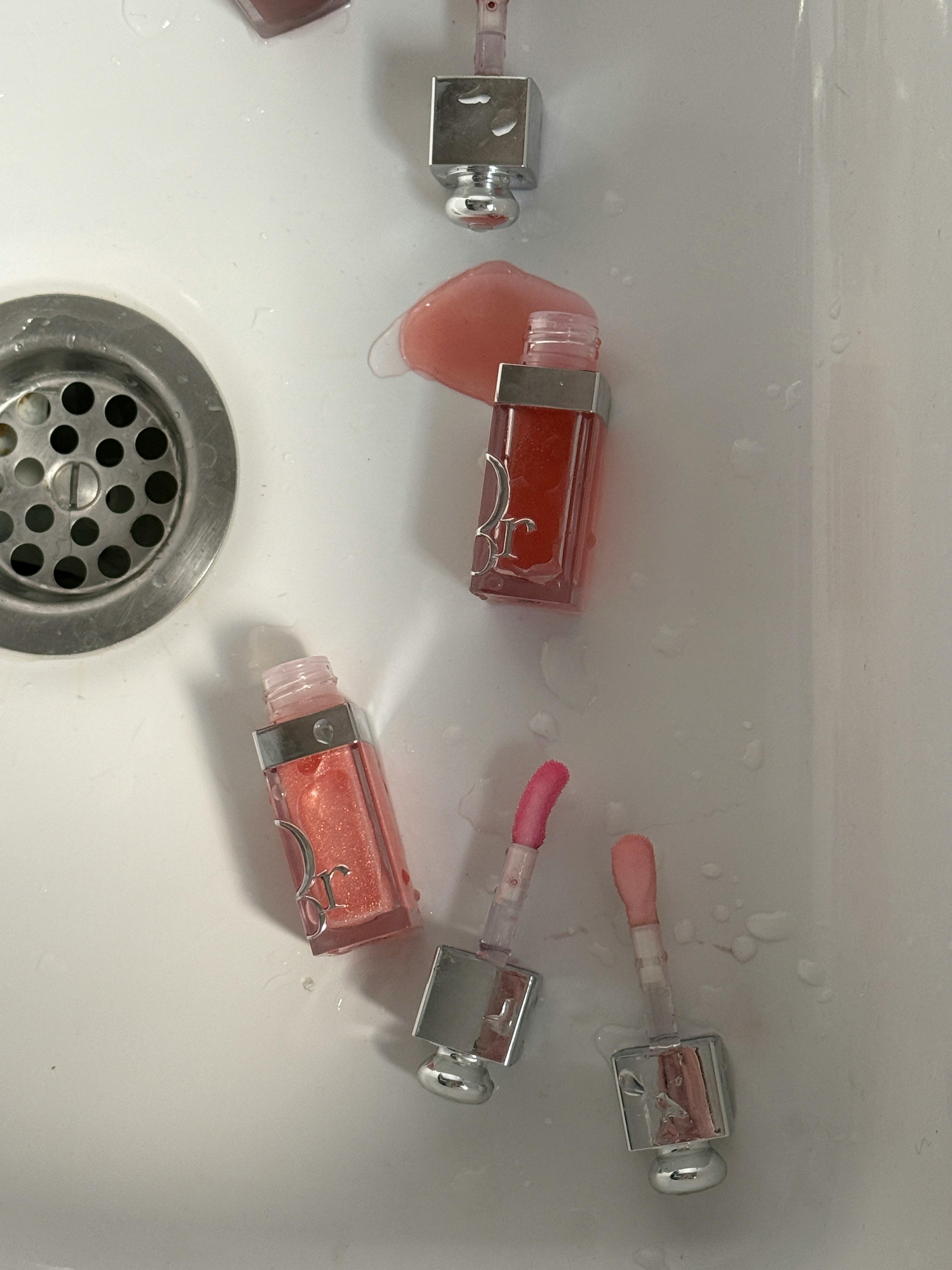 Kostenlos Öffne Lipgloss-Fläschchen mit leuchtenden Farben und Pinsel in einem weißen Waschbecken. Stock-Foto