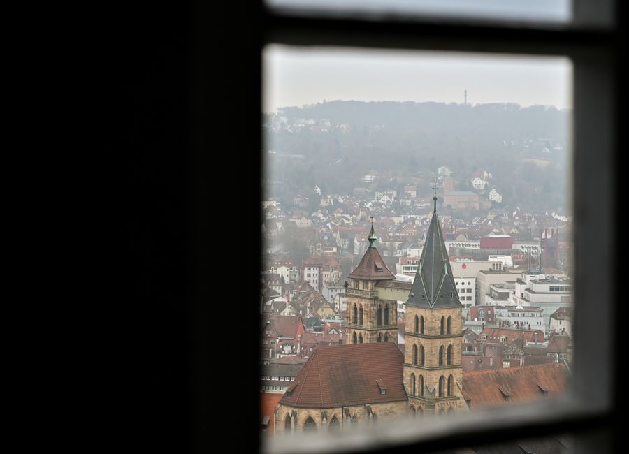 Cityscape of Stuttgart viewed through a window with a focus on historical architecture.