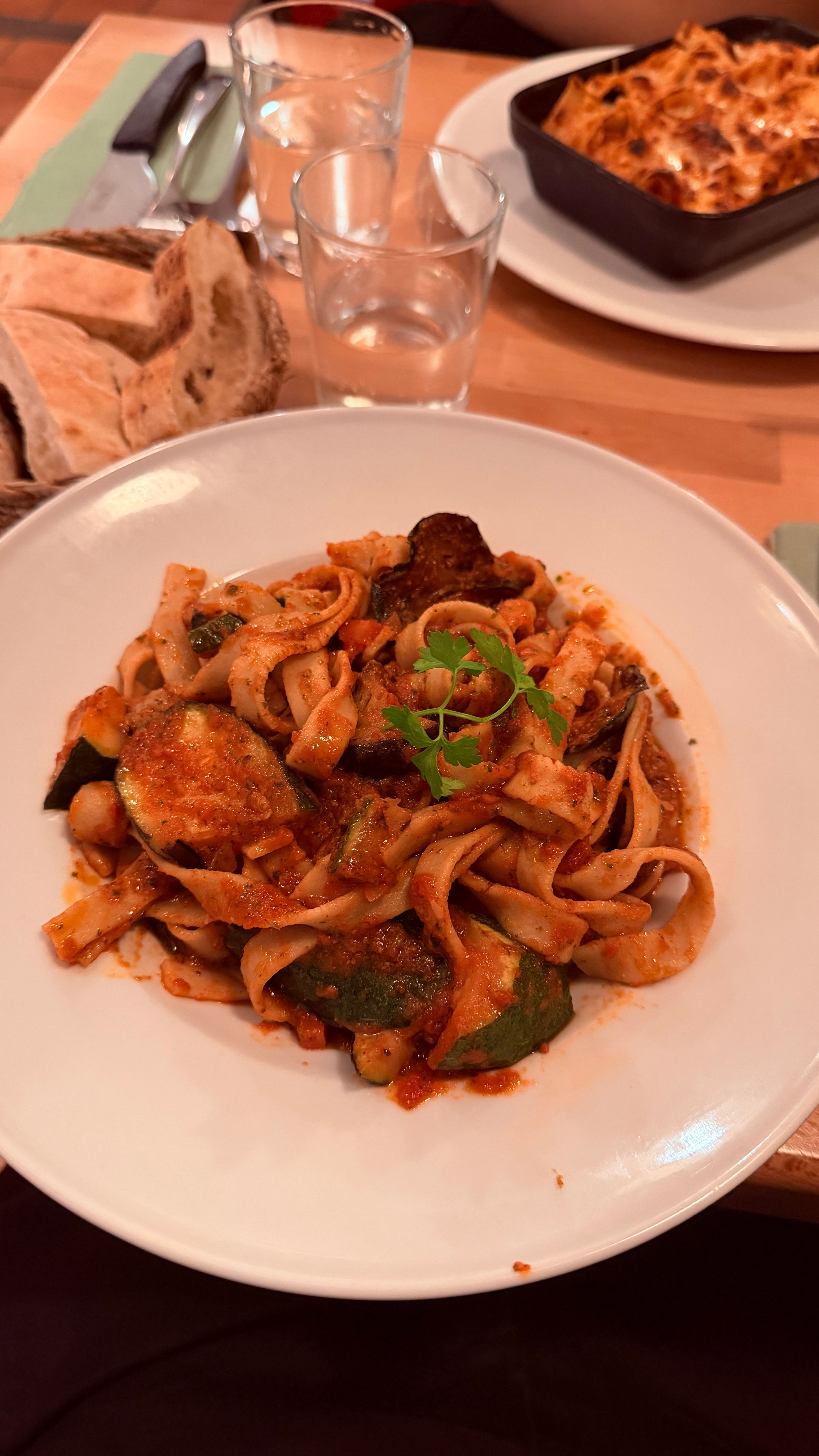 Fresh tagliatelle with vegetables served in a warm French bistro setting.