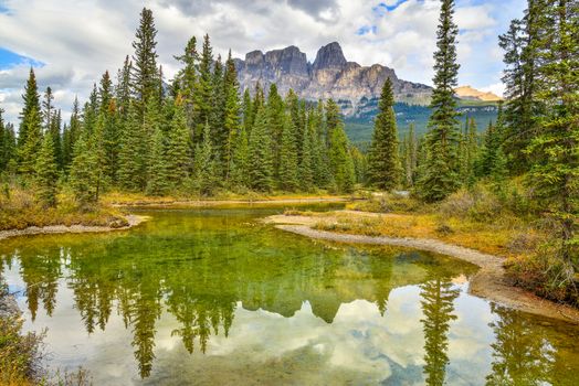 Scenic view of Castle Mountain reflecting in a tranquil lake in Banff National Park, Alberta, Canada.