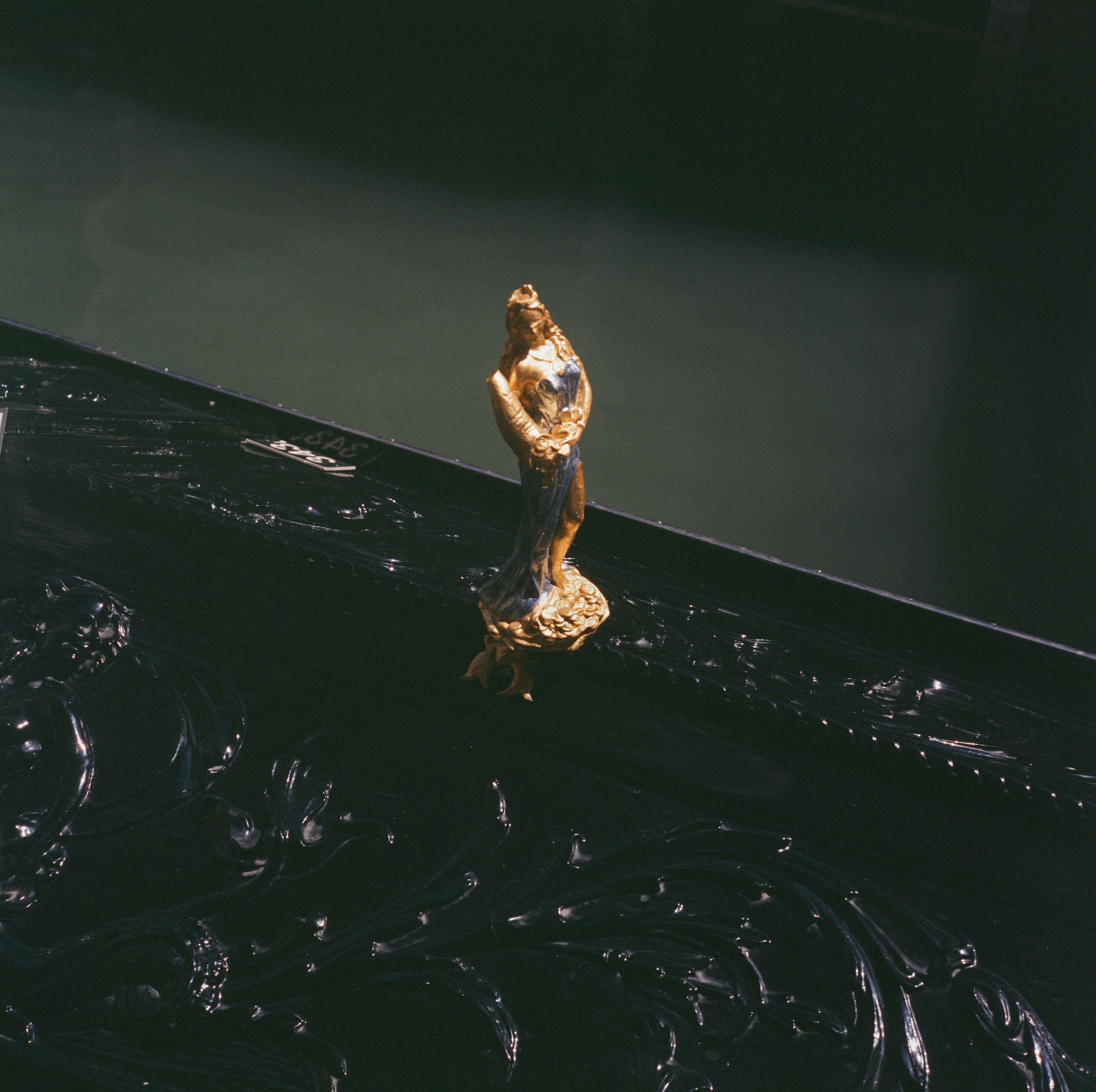 Gratis Primer plano de una estatua dorada adornada en una góndola veneciana, que refleja la artesanía italiana clásica. Foto de stock