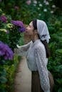 Woman Enjoying Blooming Hydrangeas Outdoors