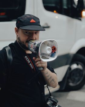 A man with a megaphone on a street in São Paulo, Brazil, conveying a message.