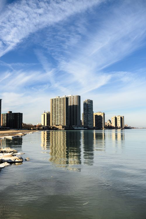 Free Chicago skyline with calm water reflections under a bright blue sky. Stock Photo