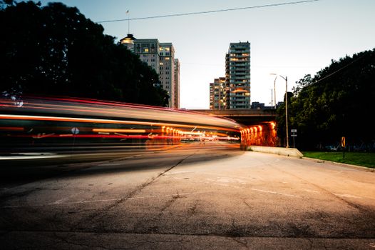 Vibrant motion blur captures a bustling Chicago street with light trails and cityscape at dusk.