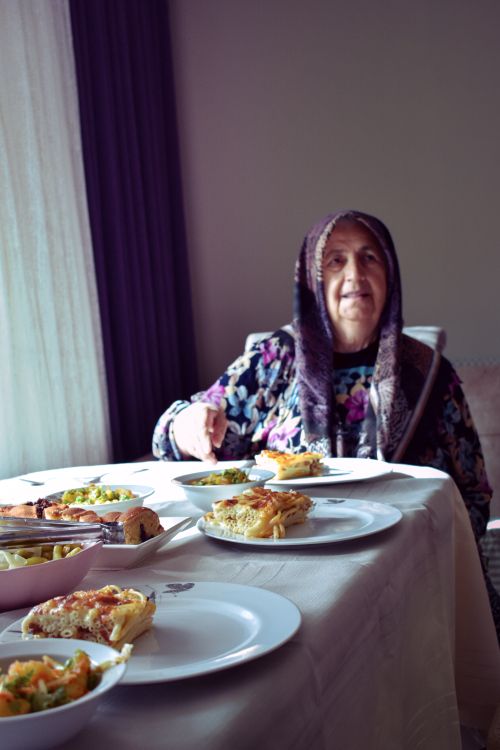 Free Senior woman in Arnavutköy dining with traditional Turkish dishes indoors. Stock Photo