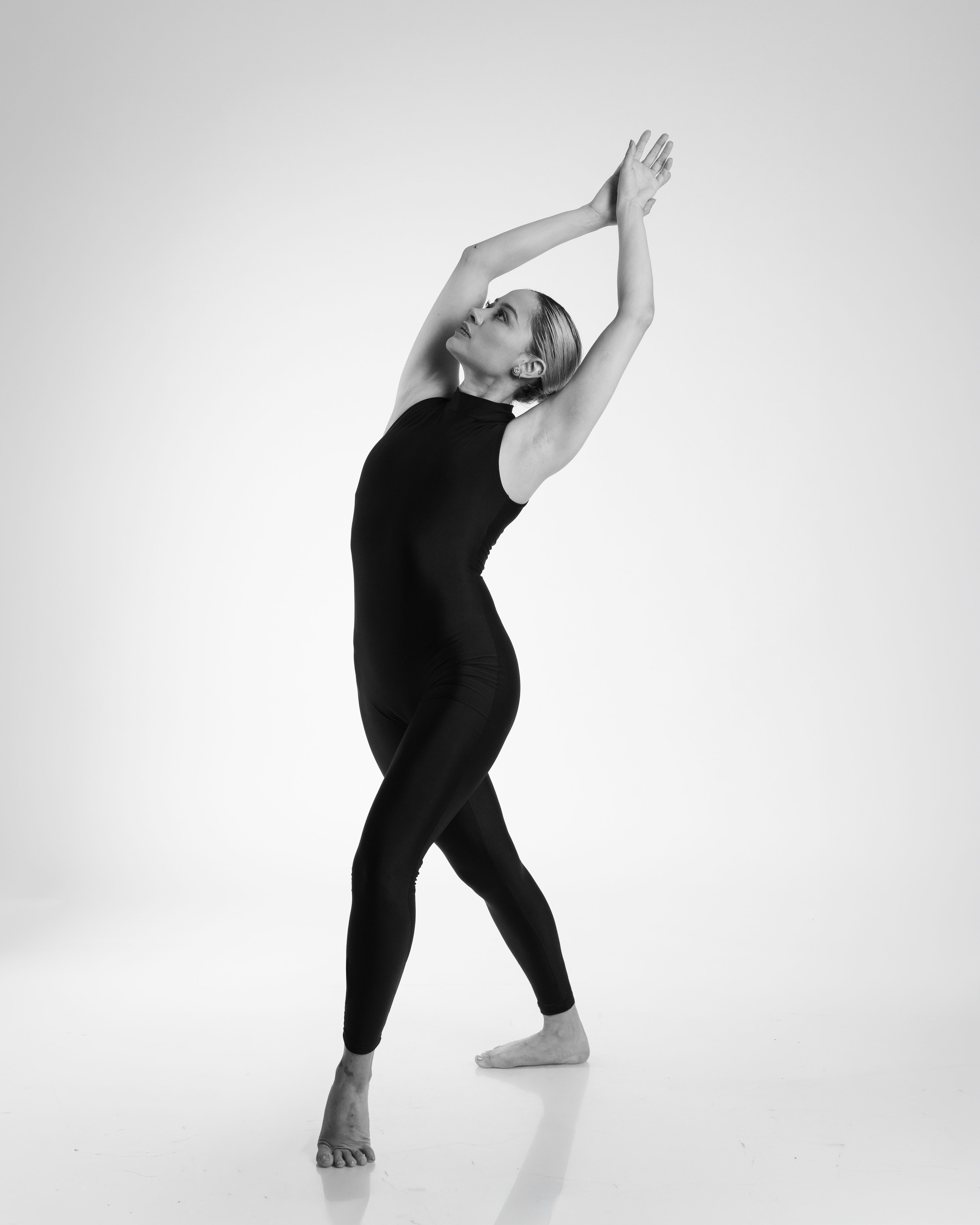 Black and white photo of a female dancer in a graceful pose, showcasing ballet elegance.