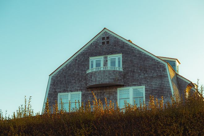 Cedar-shingled coastal house with a balcony — photo by Brent Singleton on Pexels