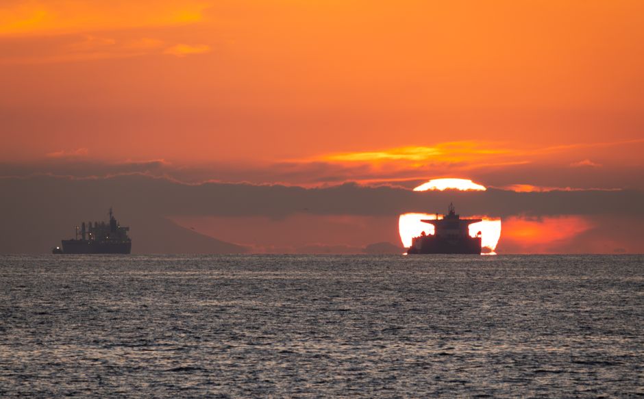 Stunning sunset view featuring ships on the horizon in Long Beach, California's Pacific Ocean.