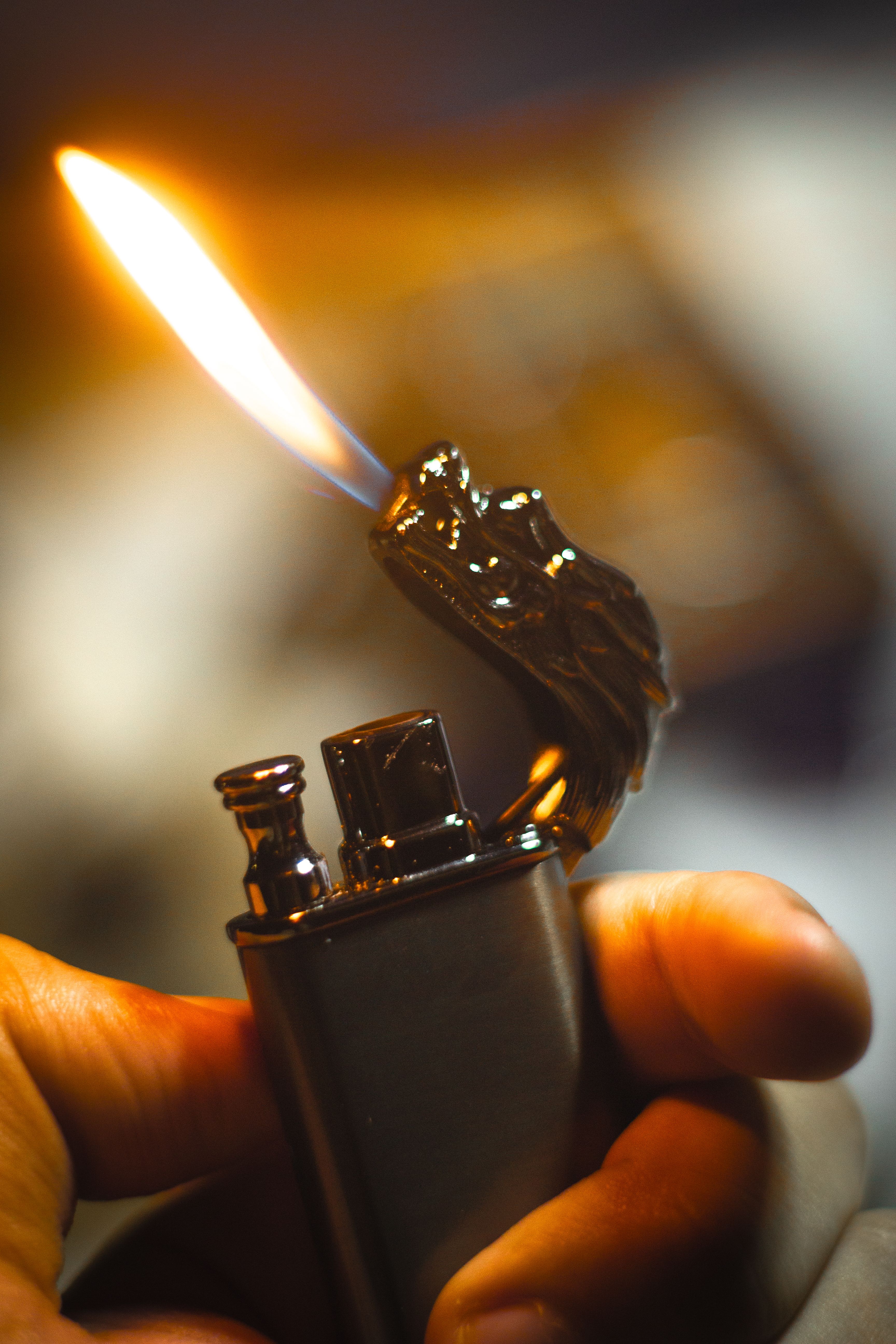 Close-up of a decorative dragon-shaped lighter with flame, captured in warm tones.