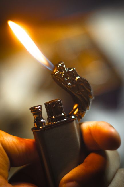 Close-up of a decorative dragon-shaped lighter with flame, captured in warm tones.