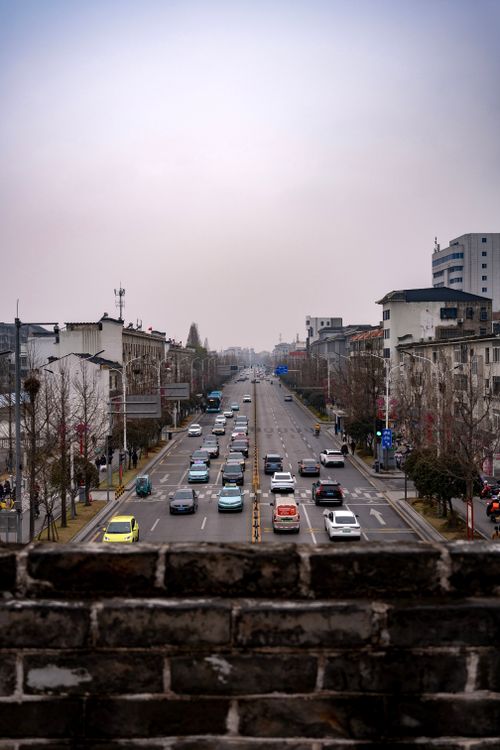 Free A bustling street scene in Jingzhou, Hubei, China, with cars and historical architecture. Stock Photo