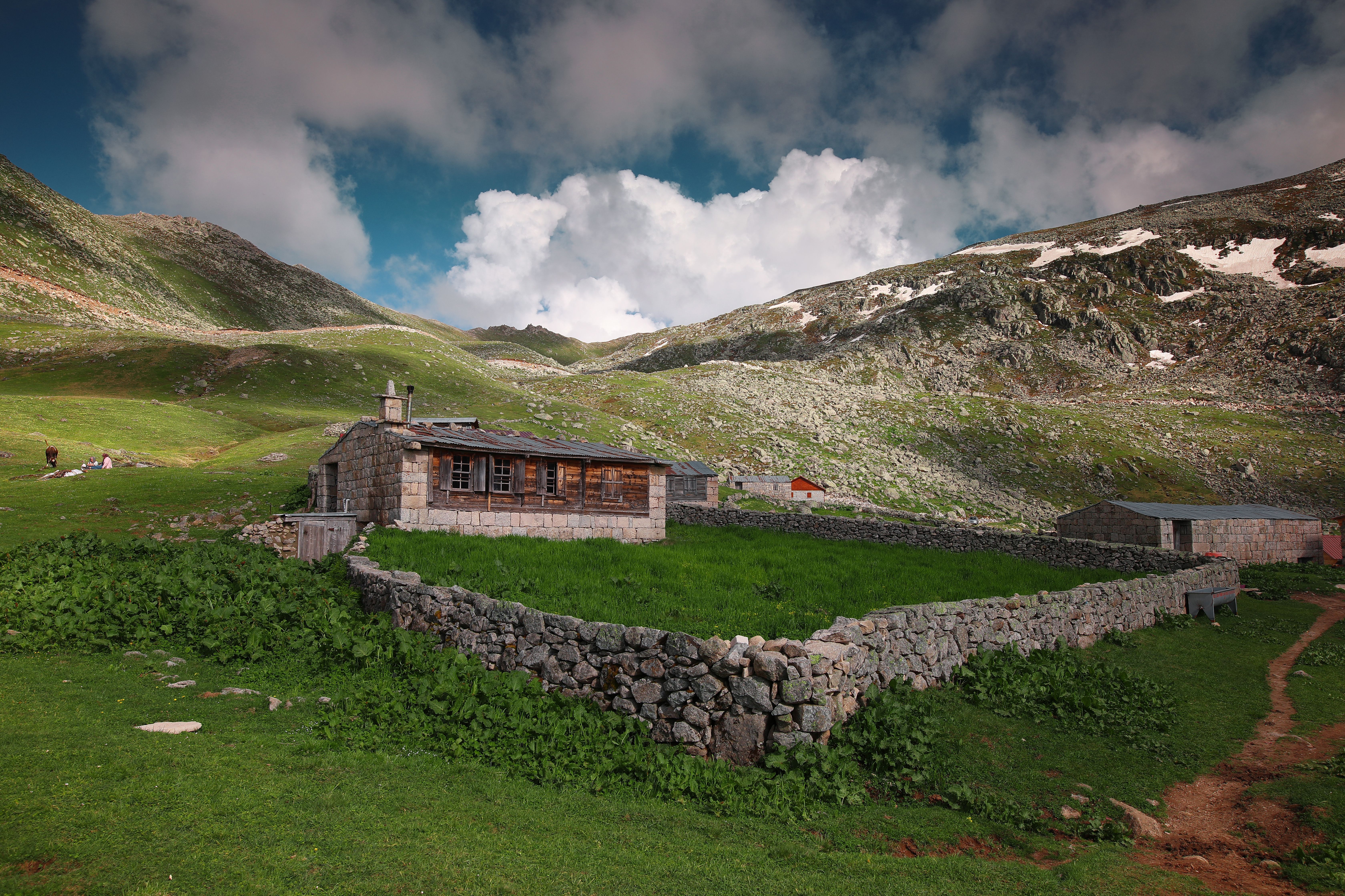 Stone cabin nestled in lush mountains, showcasing Rize's stunning landscape.