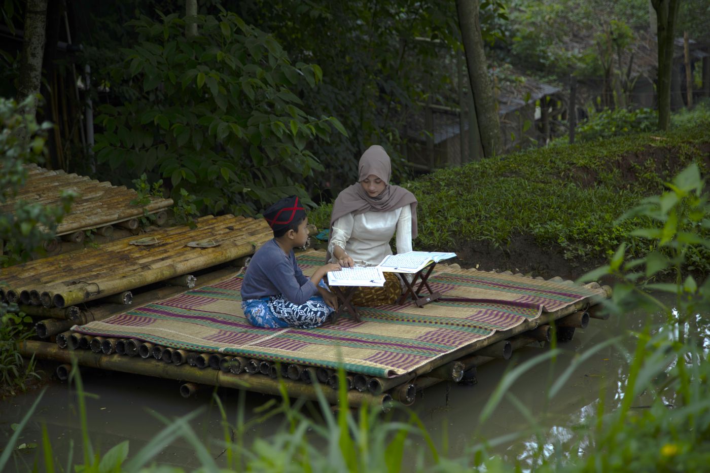 A mother and child studying together outdoors
