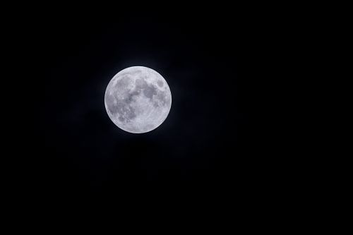 Free A glowing full moon in a clear night sky with a soft haze, photographed outdoors. Stock Photo