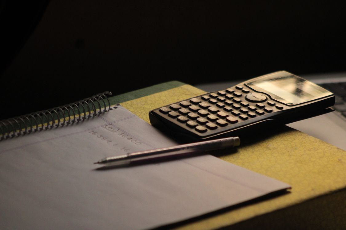 Calculator and notebook on an organized homework desk