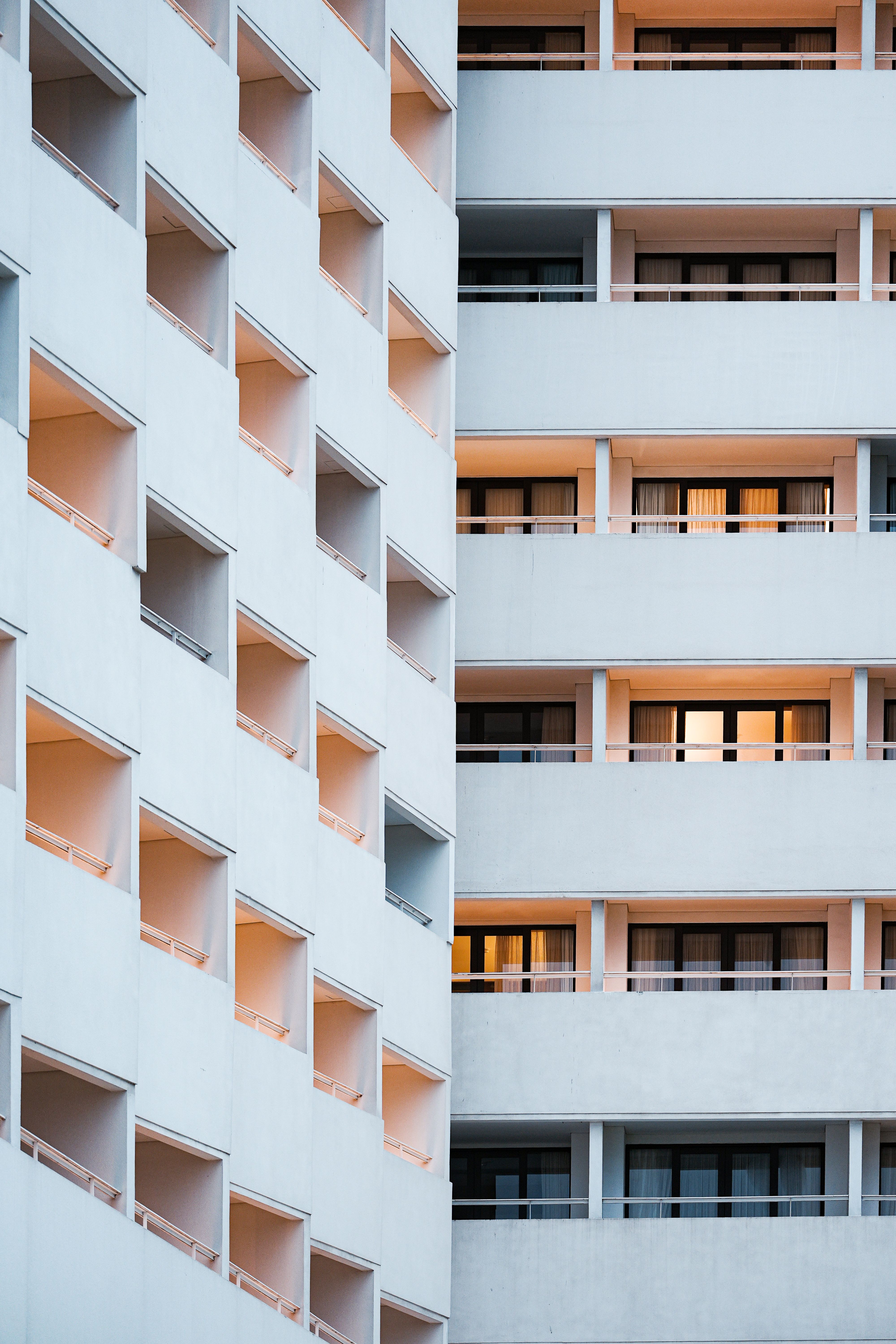 Geometric facade of a modern hotel building in Bali, Indonesia with orange lighting at twilight.