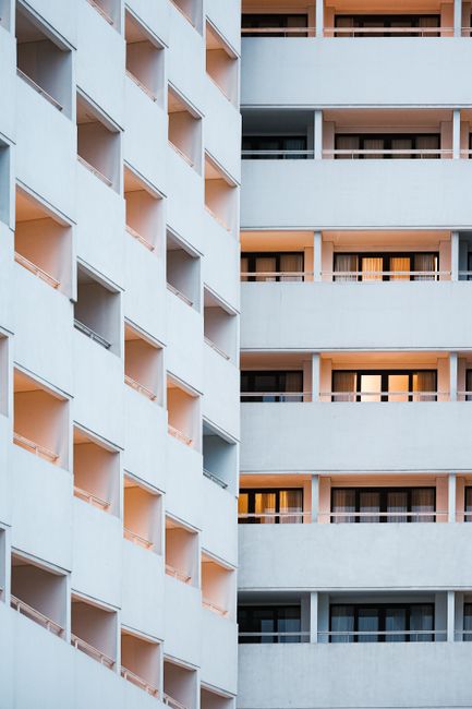 Geometric facade of a modern hotel building in Bali, Indonesia with orange lighting at twilight.