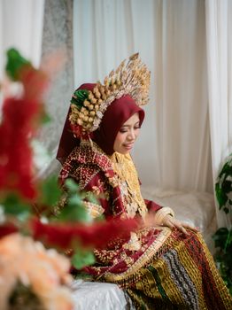 A Bugis bride in elegant traditional red garments with intricate accessories. - Fotografer Sidoarjo